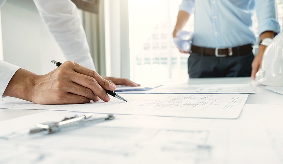 Arquitecto Ernesto Reséndiz revisando planos con cliente en sesión de diseño