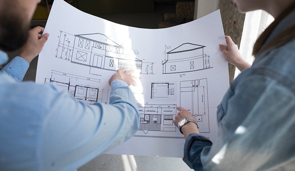 Arquitecto e ingeniero revisando planos y coordinando el diseño y la ejecución de un proyecto de construcción residencial